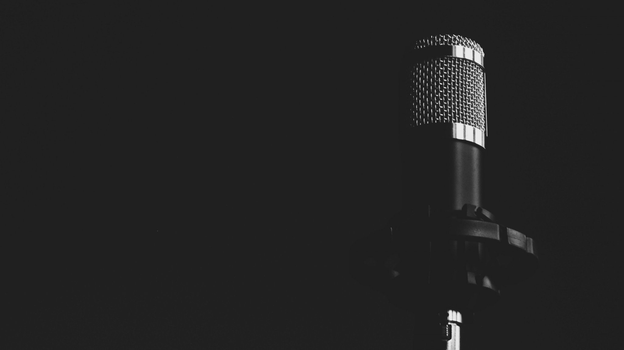 Single microphone at the centre of a dark backdrop